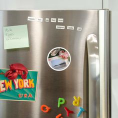 a refrigerator with magnets and letters on the door, along with a sticker that says new york