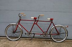 a red bicycle is parked in front of a garage door with no wheels on it