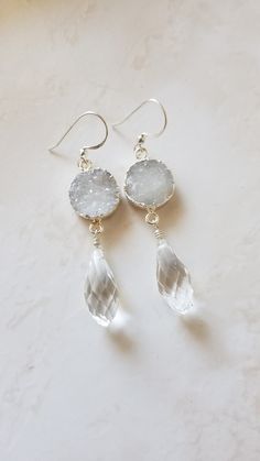 These beautiful druzy earrings are handmade with sparkly white round druzy quartz, a sparkly crystal teardrop,  and sterling silver ear wires.     A sparkly faceted crystal briollete teardrop is wire wrapped to hang from a round frosty white druzy Quartz, which hangs from a sterling silver ear wire.  The druzy itself is set in silver plate. These elegant crystal earrings make great earrings for the boho bride or bridesmaid gifts and are available in other colors and also with a mother of pearl d Blue And White Earrings, Small Dangle Earrings, Druzy Jewelry, Offbeat Bride, Mother Of Pearl Earrings, Baroque Pearl Earrings, Agate Earrings, Druzy Earrings, Sterling Silver Drop Earrings