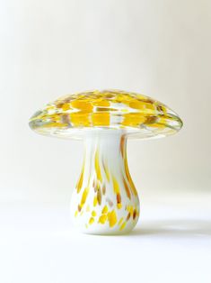 a yellow and white vase sitting on top of a table