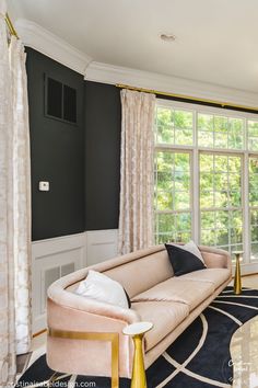 an elegant living room with black walls and white trimmings, beige couches, and gold accents