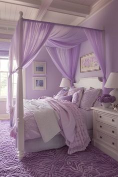 a bed with purple sheets and pillows in a room that has white furniture and windows