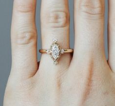 a woman's hand with a diamond ring on top of her finger and an engagement band