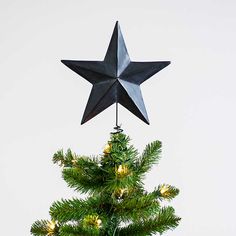 a black star hanging from the top of a christmas tree