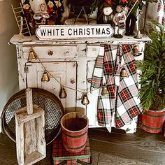 a christmas tree is sitting on top of an old dresser with ornaments and decorations around it