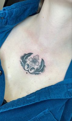 a woman's chest with a flower and butterfly tattoo on her left side breast