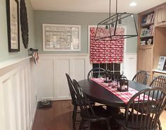 a dining room table with chairs and a red checkered table cloth on the table