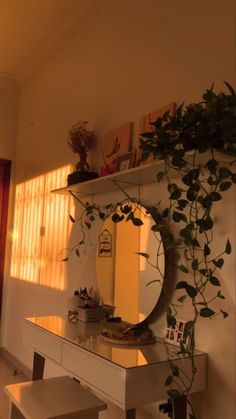 a mirror sitting on top of a white dresser next to a table with two stools