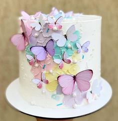 there is a white cake with many colorful butterflies on the frosting and icing