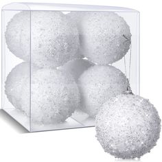 white ornaments in a clear box on a white background