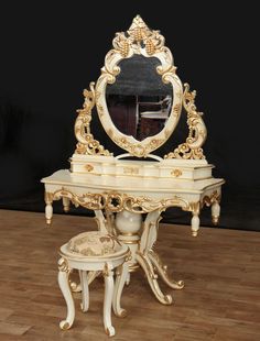 an ornate vanity with mirror and stool on wooden floor