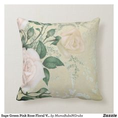 a white rose pillow with green leaves and pink flowers on the front, sitting on a beige background