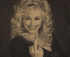 a black and white photo of a woman pointing to the side with her finger up