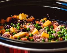 peas, rice and carrots are being cooked in the slow cooker