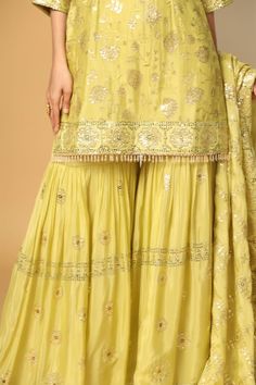 Lemon yellow three fourth sleeves padded short kurta in chinon chiffon base with all over buttercup bloom sequin embroideries and dangling glass beads on the hem. Paired with a floral sequin motif embellished flared sharara and sequin floral jaal embellished dupatta. - Aza Fashions Yellow Chikankari Embroidery Sharara For Reception, Yellow Chikankari Embroidered Sharara For Reception, Pista Green Silk Sharara With Chikankari Embroidery, Pista Green Sharara With Chikankari Embroidery For Reception, Pista Green Chikankari Embroidered Sharara For Reception, Pista Green Chikankari Sharara For Reception, Pista Green Silk Sharara For Wedding, Flared Sharara, Chiffon Embroidery