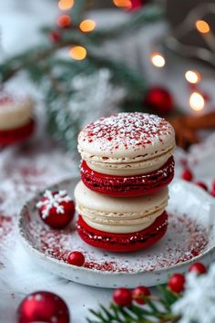 a stack of red velvet covered cookies sitting on top of a white plate next to christmas decorations