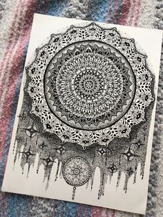 a black and white drawing on top of a piece of paper with an intricate design