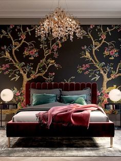 a bedroom with a bed, chandelier and paintings on the wall behind it