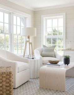 a living room filled with white furniture and windows