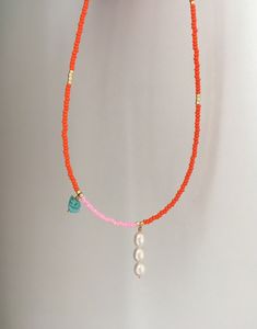 The fresh colourcombo orange, pink and turquoise adds a nice detail to your outfit. Layer it up with other necklaces for a rich look or wear it alone for a clean and chic style. 🔸SPECIFICATIONS Materials: * Beautiful orange and pink seedbeads. * Handmade pearl pendant and handmade turquoise chip bead charm with goldplated wire. * 14k gold filled high quality clasp and extender chain, for your jewelry to last. ❤Handmade with love by me in my jewelrystudio in Oslo, Norway. 🔸SIZE: Adjustable with Coral And Turquoise Necklace, Trendy Necklaces Beads, Pink Seed Bead Necklace, Pearl Bead Necklace, Beading Jewelry, Beaded Necklace Ideas, Boho Chique, Pink Pearl Necklace, Boho Chic Necklace