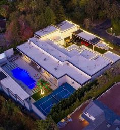 an aerial view of a house with a pool and tennis court