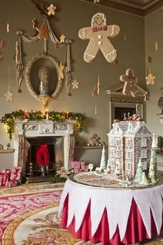 a gingerbread house is on display in a room decorated with christmas decorations and garlands