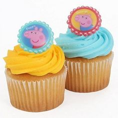 two cupcakes with peppa the pig toppers on each one are blue and yellow