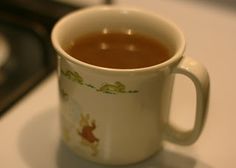 a cup of hot chocolate sitting on top of a counter next to a burner