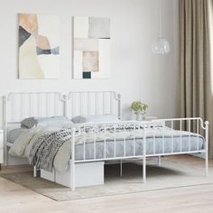 a white bed sitting in a bedroom next to a window