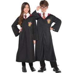 two children wearing harry potter robes and holding their hands on their hipss while standing next to each other