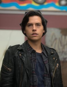 the young man is wearing a leather jacket