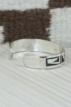 This sterling silver bracelet was made by Hopi silversmith Timothy Mowa. The inside is signed and stamped sterling.Size: 5 5/8" (will fit up to a 6 3/8" wrist)Gap: 3/4"Width: 1/2"Free shipping on all orders! We ship with USPS and always include tracking. All orders ship within a day of payment.Returns are accepted up to 30 days after you receive your order. Just send us a message. Our shop offers cash back or store credit. The item must be returned in new condition. Modern Adjustable Bracelet Stamped 925, Modern Adjustable 925 Stamped Bracelets, Modern Adjustable 925 Stamped Bracelet, Artisan Sterling Silver Bangle Bracelet, Sterling Silver Southwestern Bangle For Gift, Sterling Silver Etched Bangle Bracelet, Southwestern Sterling Silver Bangle Gift, Southwestern Sterling Silver Bangle For Gift, Sterling Silver Etched Bracelets For Anniversary