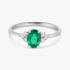 "Handmade by an inspired jewelry artist team with decades of experience in the craft of jewelry making. Each gemstone, each diamond is carefully picked. Using only the finest raw materials and the highest industry standard in manufacturing, design and finish. A beautiful vintage inspired piece handmade just for you. Set with a beautiful 7x5 mm Green Chatham Emerald Grade AAA, Oval cut, 1.05ct and 6 sparkling Diamonds, 1.75 mm, VS-E 0.13 ctw. The ring has a dainty band of 1.3 mm so perfect for da Timeless Oval Emerald Rings, Exquisite Oval Emerald Ring With Accent Stones, Oval Emerald Birthstone Ring For Wedding, Oval Emerald Birthstone Wedding Ring, Heirloom Oval Emerald Ring As May Birthstone, Oval Emerald May Birthstone Ring, Oval Emerald Birthstone Ring In White Gold, Oval Emerald Birthstone Ring For May, Heirloom Oval Emerald Ring In White Gold