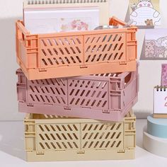 three plastic crates stacked on top of each other in front of a notepad holder