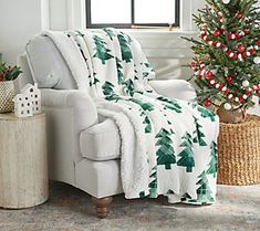 a living room with a christmas tree in the corner and a chair next to it