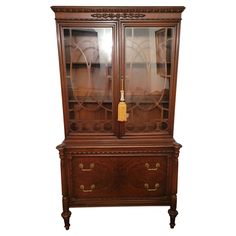 a wooden china cabinet with glass doors and drawers