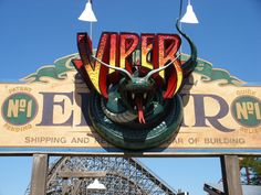 a large sign that is on the side of a building in front of a roller coaster