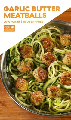 a pan filled with pasta and meatballs on top of a wooden table