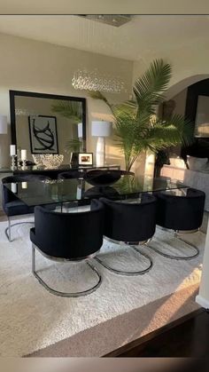 a dining room table with four chairs and a plant in the middle of the room