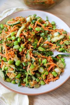 a white plate topped with rice and veggies on top of a wooden table