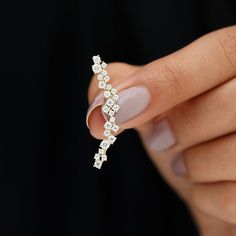 a woman's hand holding a diamond ring with two rows of diamonds on it