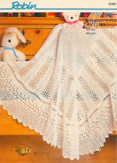 a white crocheted blanket on top of a dresser next to a teddy bear