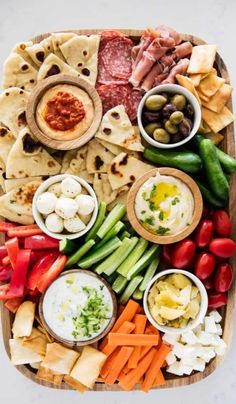 a platter filled with different types of food including pita breads and vegetables