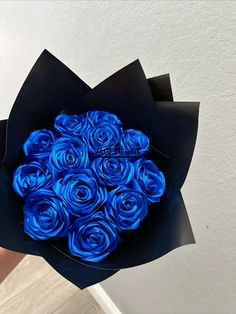 a bouquet of blue roses in a black box