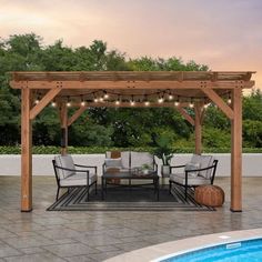 an outdoor dining area next to a pool with string lights on the pergoline