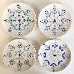 four blue and white plates with snowflakes on them