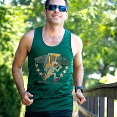 Embrace the spirit of running with our men's performance tank featuring The Tortured Runners Club design. Made from moisture-wicking material, this tank ensures runners stay dry and cool. The comfortable and relaxed fit pairs effortlessly with any athletic or casual bottoms. Ideal for everyday wear and perfect as a gift for runners, this performance tank top is a versatile addition to any wardrobe. Dri-fit Athletic Fit Activewear For Running, Green Athletic Fit Activewear For Sports Events, Summer Athleisure Activewear For Marathon, Breathable Athleisure Activewear For Marathon, Sporty Go-dry Tank Top For Sports Events, Sporty Athletic Fit Activewear For Marathon, Athletic Fit Dri-fit Activewear For Sports, Sporty Athletic Fit Tank Top For Sports, Sporty Tank Top With Team Name For Sports