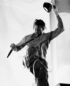 a man is jumping in the air with a hat on his head and holding a baseball bat