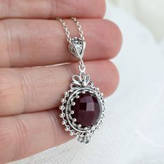 This beautiful ruby corundum silver pendant necklace is a one-of-a-kind handmade item that exudes mid-century style. The pendant features a stunning ruby gemstone set in a filigree silver design that measures 0.80 inches in width and 1.50 inches in height. The necklace itself is 20 inches in length and crafted from high-quality silver materials. Highlights:  - Handmade item - Ships from a small business in New York - Mid-century style - Ruby Corundum gemstone - Filigree silver pendant necklace - Necklace length: 20 inches Benefits:  This ruby silver pendant necklace is a unique and stunning piece of jewelry that is sure to make a statement. It is perfect for those who appreciate handmade items and mid-century style, and the ruby gemstone adds a touch of luxury and elegance. The filigree si Handmade Oval Ruby Necklace, Silver Garnet Necklaces For Gifts, Handmade Ruby Round Pendant Jewelry, Handmade Ruby Pendant Jewelry, Ornate Ruby Jewelry As A Gift, Ornate Ruby Jewelry Gift, Ornate Ruby Jewelry For Gifts, Handmade Ruby Necklace For Gift, Ruby Filigree Jewelry As A Gift