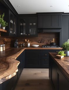 a wooden counter top in a kitchen next to black cupboards and counters with plants on it